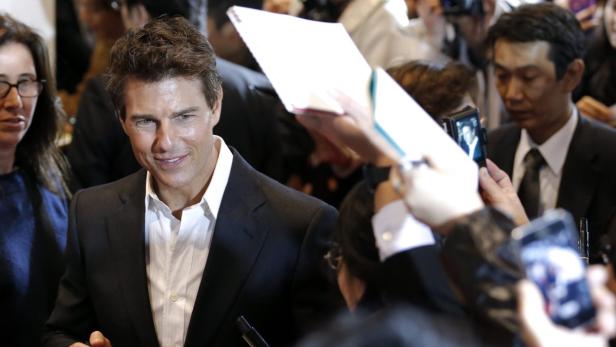 Tom Cruise posiert für Fotos auf einer Veranstaltung.