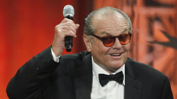 Jack Nicholson hält ein Mikrofon in der Hand und lächelt.