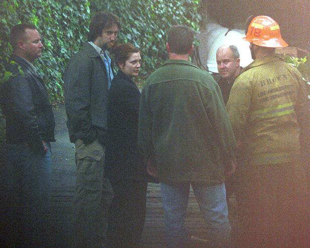 Eine Gruppe von Personen, darunter ein Feuerwehrmann, steht im Freien.