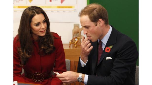 Prinz William leckt sich den Finger, während Kate Middleton zusieht.
