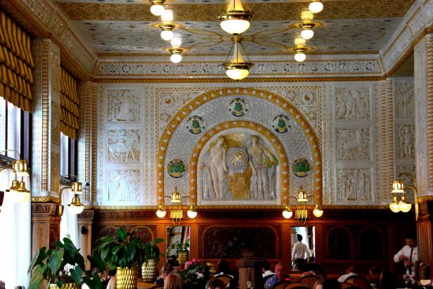 Das kunstvoll dekorierte Interieur eines Cafés mit Gästen an Tischen.