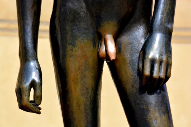 Detailaufnahme einer männlichen Bronzestatue.