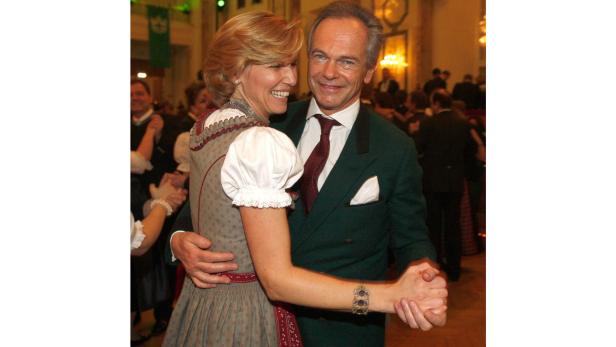 Ein Mann im Anzug tanzt mit einer Frau im Dirndl.