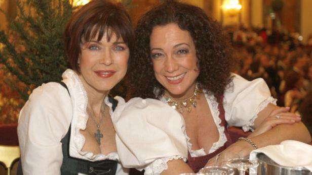 Zwei Frauen im Dirndl lächeln in die Kamera.