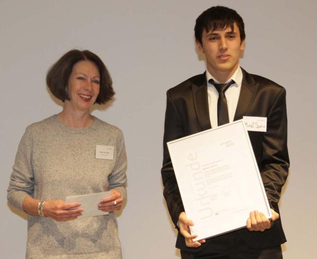 Murat Spahiu erhält eine Urkunde von einer Frau.