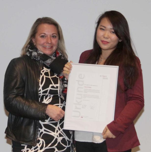 Zwei Frauen präsentieren eine Urkunde mit dem Namen Lisa Zhang.