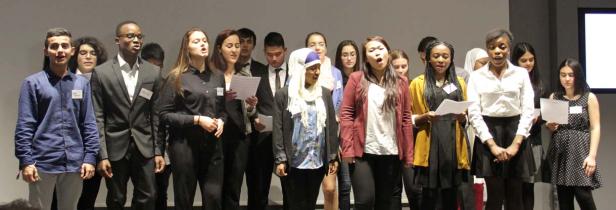 Eine vielfältige Gruppe junger Menschen singt in einem Chor.