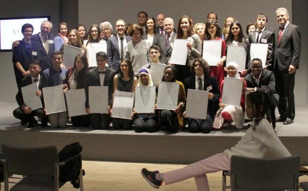 Eine Gruppe von Preisträgern hält ihre Urkunden auf einer Bühne.
