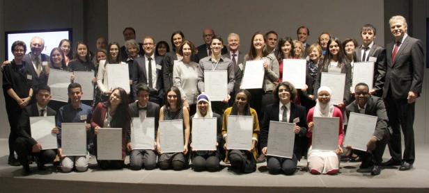 Eine Gruppe von Preisträgern posiert mit ihren Urkunden für ein Gruppenfoto.