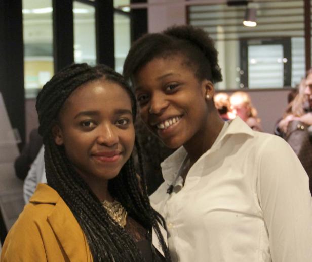 Zwei junge, lächelnde Frauen posieren für ein Foto.