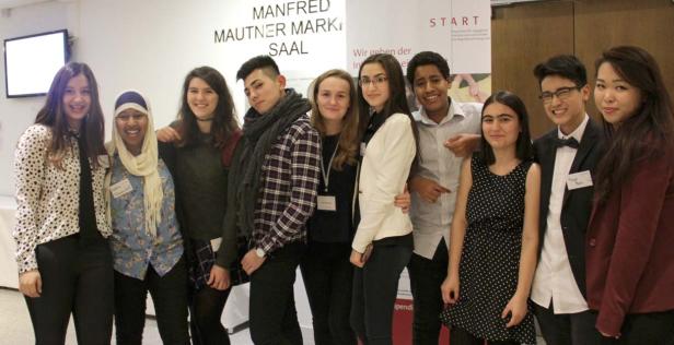 Eine Gruppe von zehn jungen Menschen posiert vor einem Schild mit der Aufschrift „Manfred Mautner Markhof Saal“.