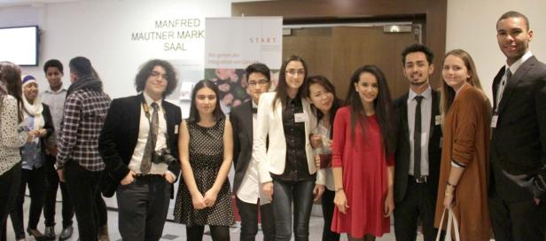 Eine Gruppe junger Menschen posiert vor einem Schild mit der Aufschrift „Manfred Mautner Mark Saal“.