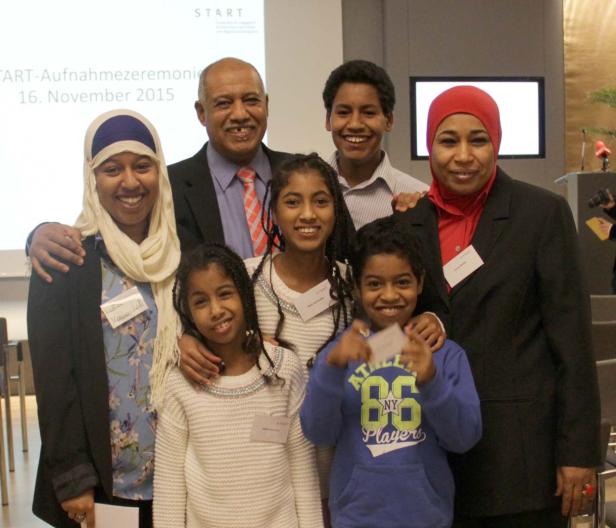 Eine Gruppe von Menschen posiert lächelnd für ein Foto bei einer Veranstaltung.