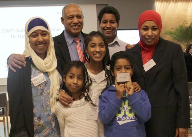 Eine Gruppe von Menschen, darunter Kinder und Erwachsene, posiert für ein Gruppenfoto.