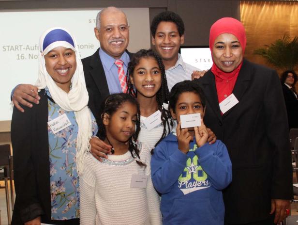 Eine Gruppe von Menschen unterschiedlichen Alters posiert für ein Gruppenfoto.