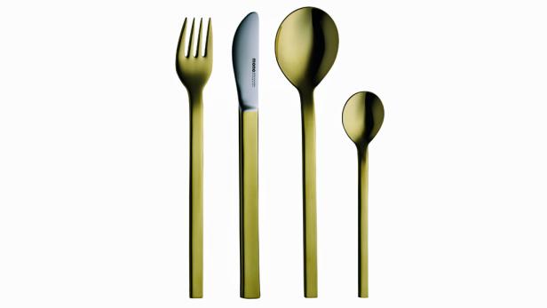 Ein goldenes Besteckset mit Messer, Gabel, Esslöffel und Teelöffel auf weißem Grund.