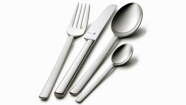 Ein Besteckset mit Messer, Gabel, großem Löffel und kleinem Löffel liegt auf einem weißen Untergrund.