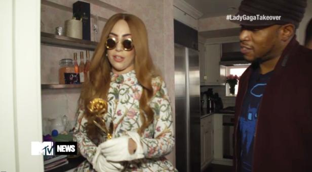 Lady Gaga mit Sonnenbrille und goldener Rose in der Hand.