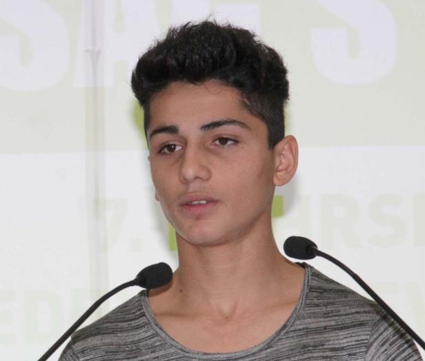 Ein junger Mann spricht vor zwei Mikrofonen.