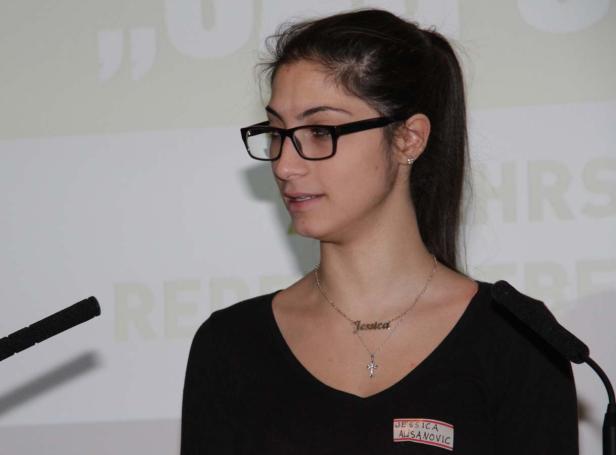Jessica Alisanovic spricht bei einer Veranstaltung am Mikrofon.