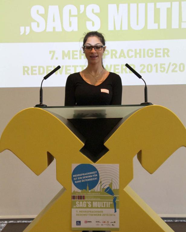 Eine Frau steht an einem gelben Rednerpult bei der Veranstaltung „Sag's Multi!“.