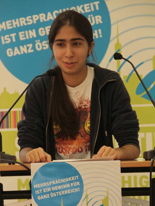 Eine junge Frau spricht bei einer Veranstaltung zum Thema Mehrsprachigkeit in Österreich.