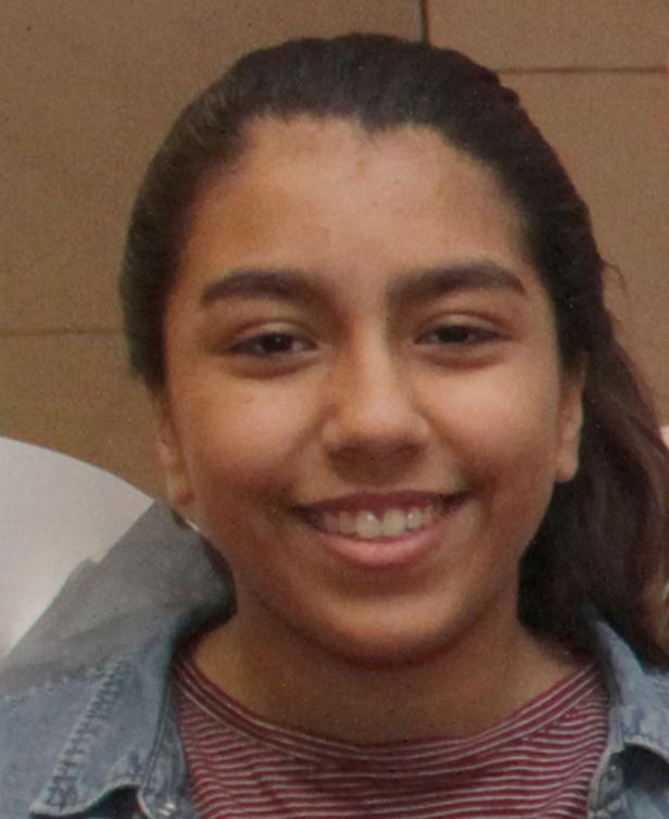 Porträt einer lächelnden jungen Frau mit dunklen Haaren.