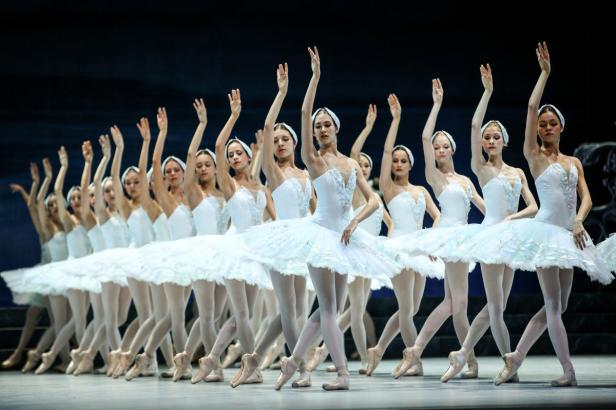 Eine Gruppe von Ballerinen in weißen Tutus auf einer Bühne.
