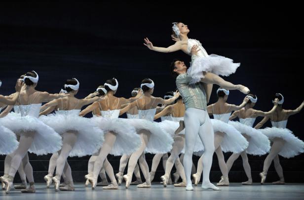 Eine Ballettaufführung mit einer Tänzerin, die von einem Tänzer hochgehoben wird, umgeben von anderen Tänzerinnen.