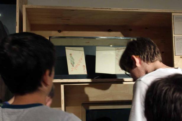 Zwei Personen betrachten eine Zeichnung in einer Vitrine.