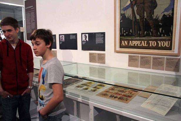 Zwei Jungen betrachten eine Ausstellung mit einem Plakat mit der Aufschrift „An Appeal to You“.