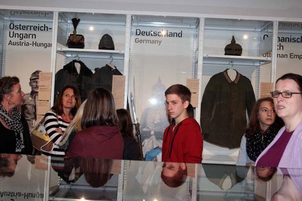 Besucher betrachten in einem Museum Ausstellungsstücke aus Deutschland und Österreich-Ungarn.