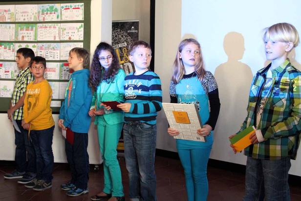 Eine Gruppe von Kindern steht vor einer Wand mit Zeichnungen.