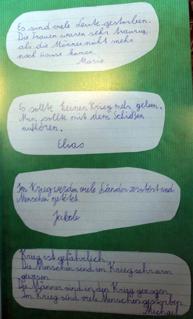 Auf einem grünen Hintergrund befinden sich Zettel mit handgeschriebenen Texten über den Krieg.