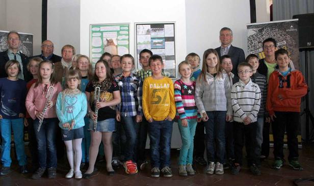 Eine Gruppe von Kindern und Erwachsenen posiert für ein Gruppenfoto.