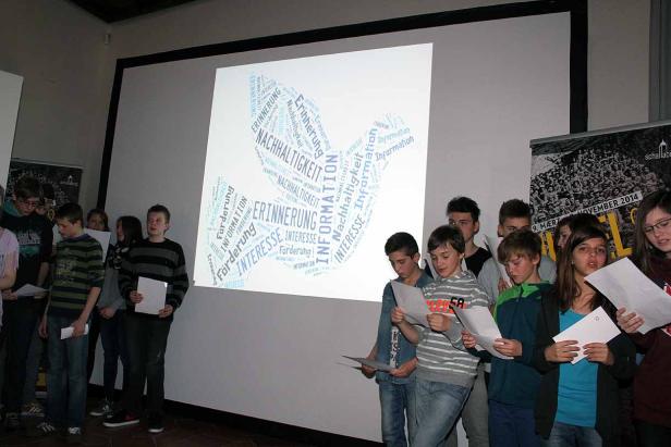 Eine Gruppe von Schülern steht vor einer Leinwand mit einer Wortwolke zum Thema Nachhaltigkeit.