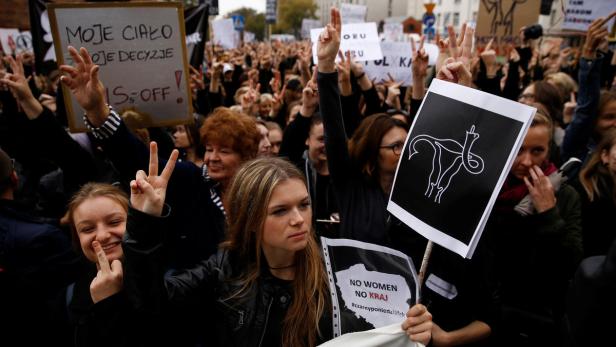 Eine Demonstration für Frauenrechte mit Schildern und Parolen in Polen.