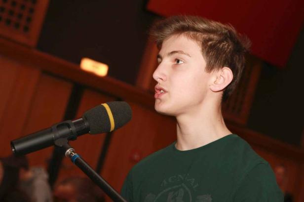 Ein junger Mann spricht in ein Mikrofon.