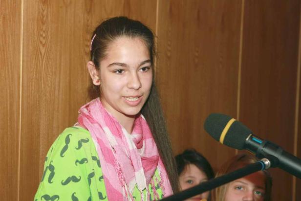 Ein junges Mädchen spricht vor einem Mikrofon.