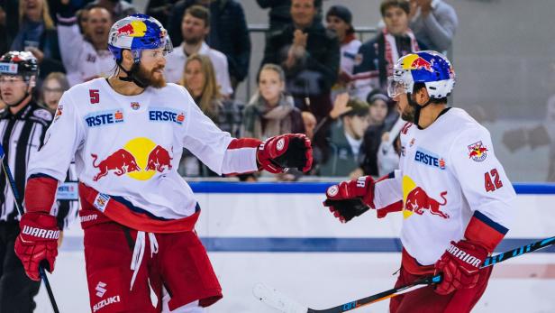 Zwei Eishockeyspieler der Red Bulls begrüßen sich auf dem Eis.
