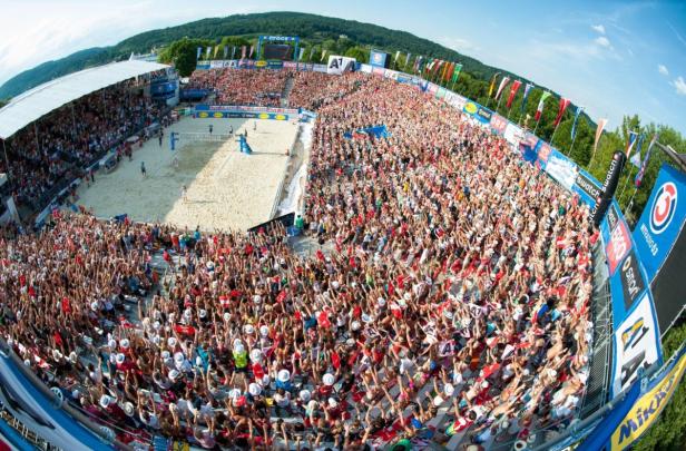 Ein Beachvolleyballturnier mit vielen Zuschauern auf den Tribünen.