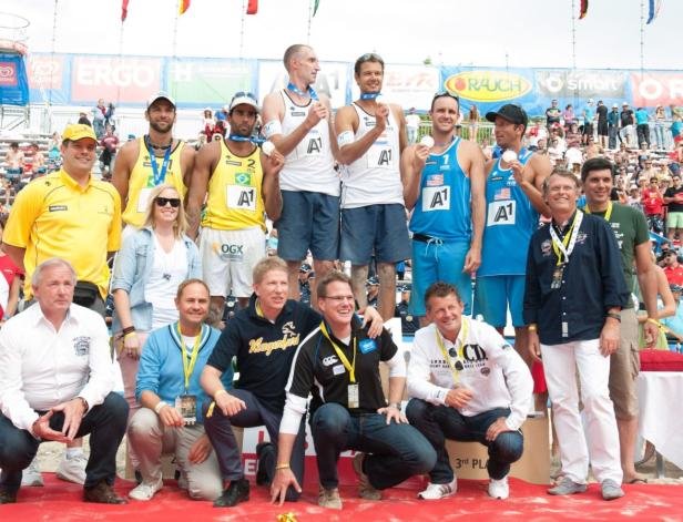 Beachvolleyball-Teams posieren mit ihren Medaillen auf dem Siegerpodest.