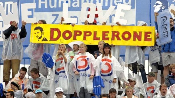 Zuschauer halten Schilder mit der Aufschrift „Dopplerone“ und „We Love“ in die Höhe.