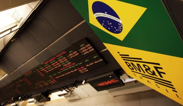 Eine Anzeigetafel mit Börseninformationen vor der brasilianischen Flagge und dem BM&F-Logo.