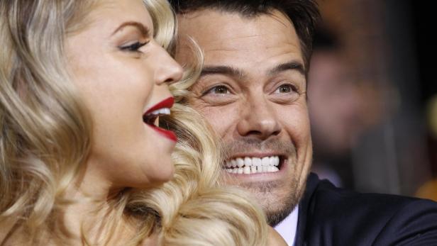 Fergie und Josh Duhamel lächeln auf einem Event in die Kamera.
