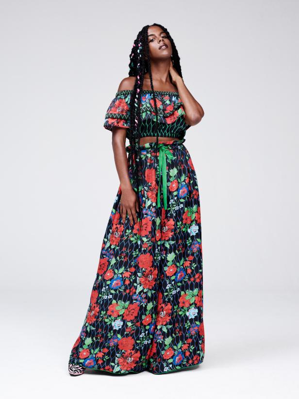 Eine Frau mit Zöpfen trägt ein florales zweiteiliges Outfit.