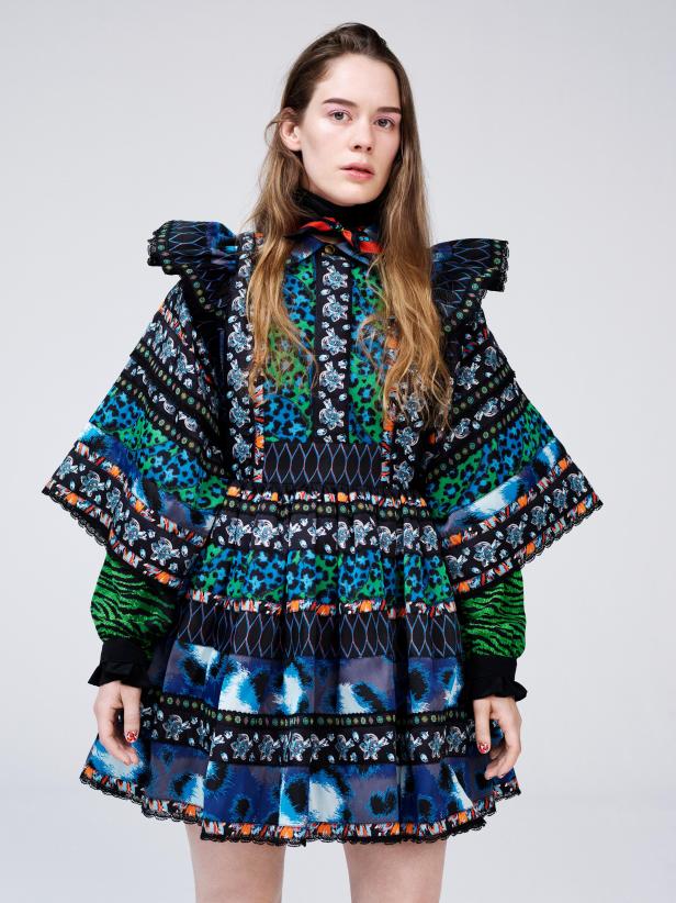 Eine Frau trägt ein bunt gemustertes Kleid mit Rüschen und Puffärmeln.