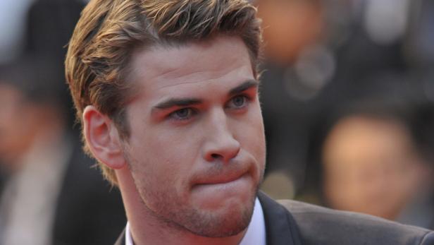 Porträt von Liam Hemsworth mit blonden Haaren und blau-grauen Augen.