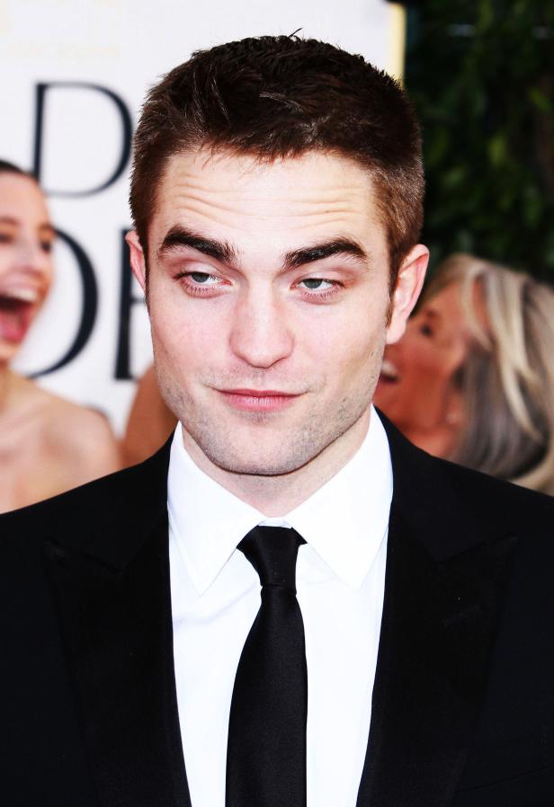 Robert Pattinson auf dem roten Teppich mit einem schelmischen Gesichtsausdruck.