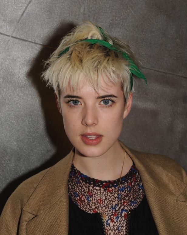 Eine Frau mit blonden, kurzen Haaren und einem grünen Haarband blickt in die Kamera.